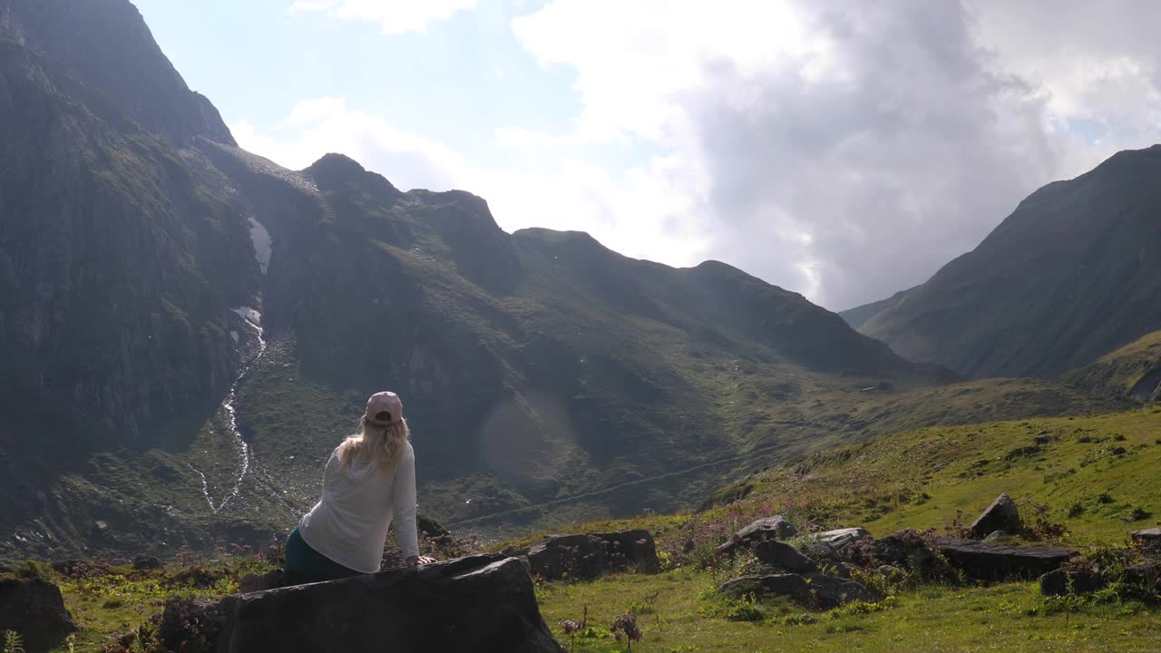 女徒步旅行者在山间草地上放松视频素材