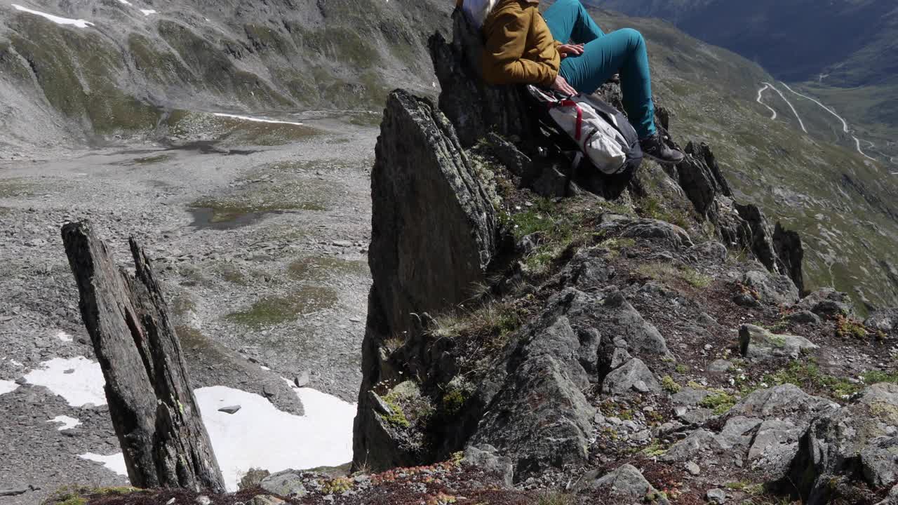 女徒步旅行者在山顶放松，用智能手机视频素材