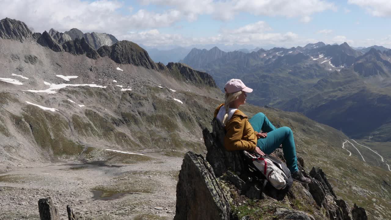 女徒步旅行者在山顶放松，用智能手机视频素材