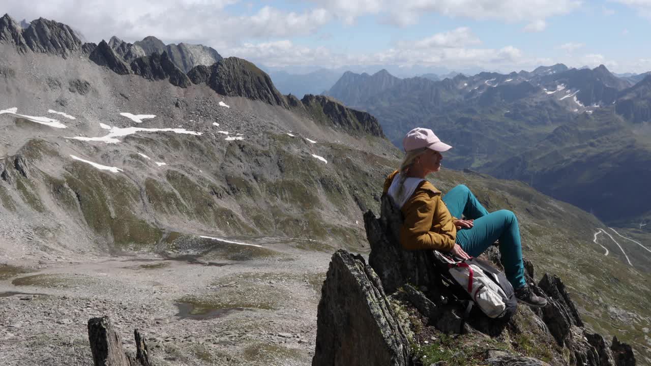 女徒步旅行者在山顶放松，用智能手机视频素材