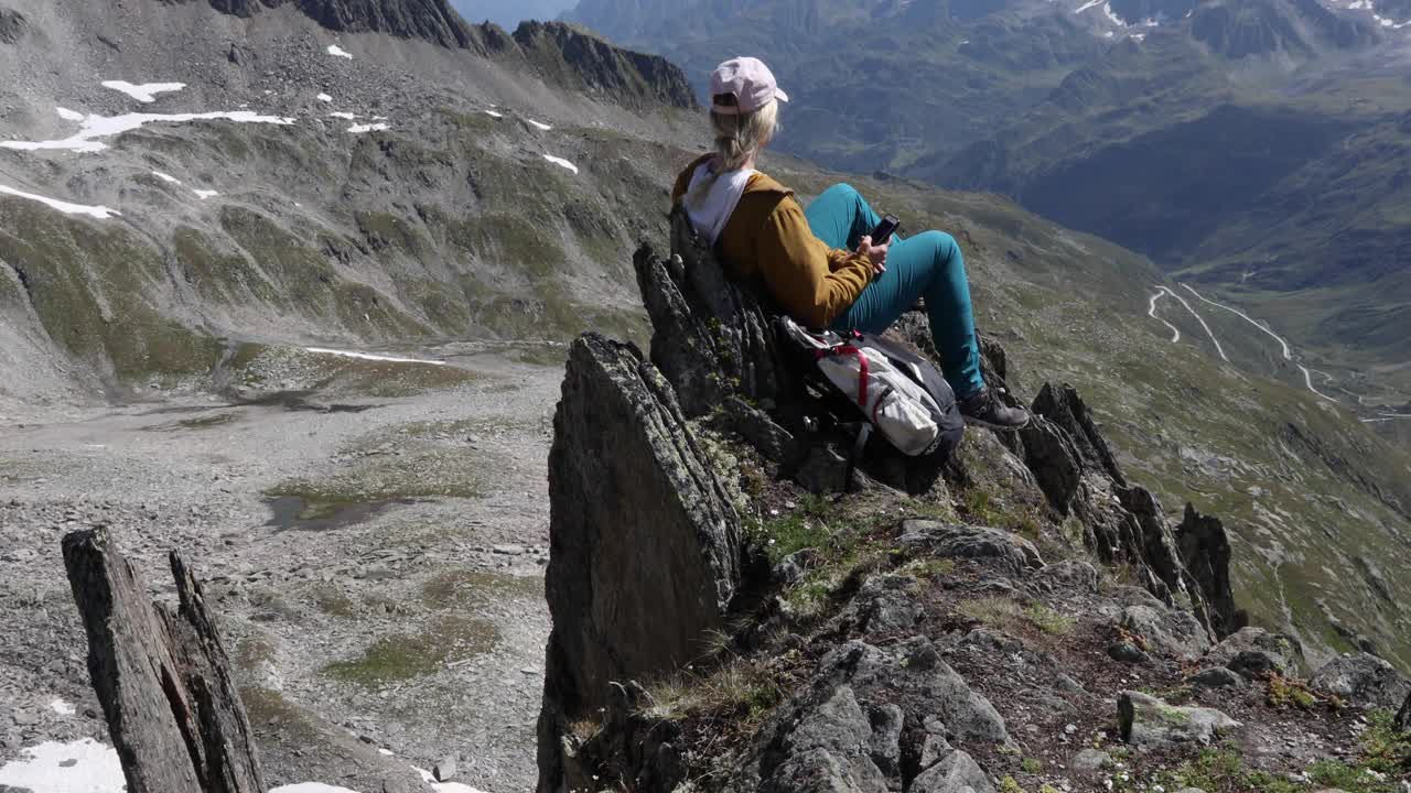 女徒步旅行者在山顶放松，用智能手机视频素材