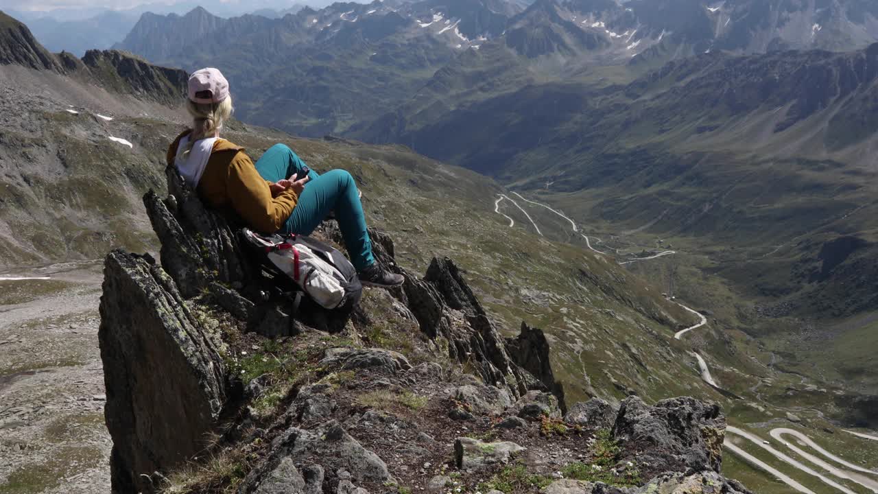 女徒步旅行者在山顶放松，用智能手机视频素材