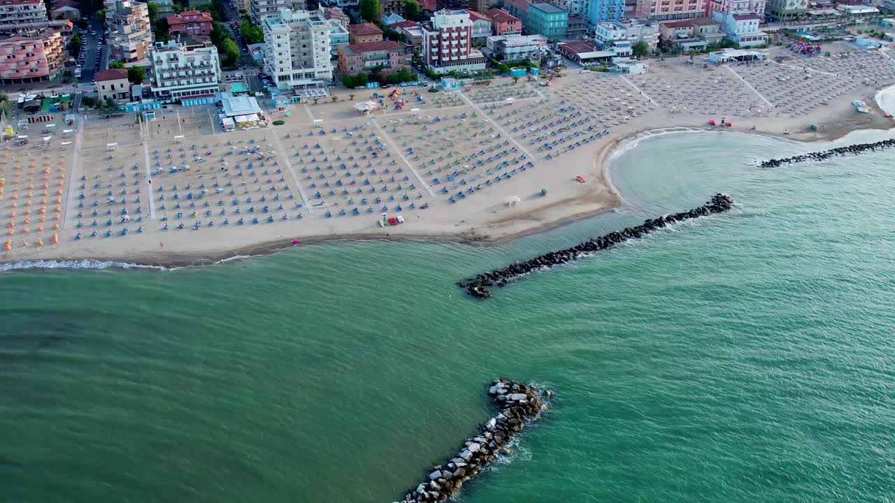 空中4K镜头的里米尼海滩，许多海滩伞和城市全景视频素材