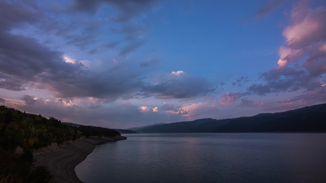 时间流逝——爱达荷州蛇河水库上方令人惊叹的山脉景观与引人注目的云层视频素材