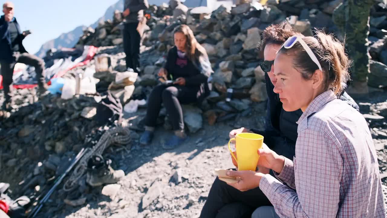 登山者在帐篷旁边的营地吃东西。视频素材