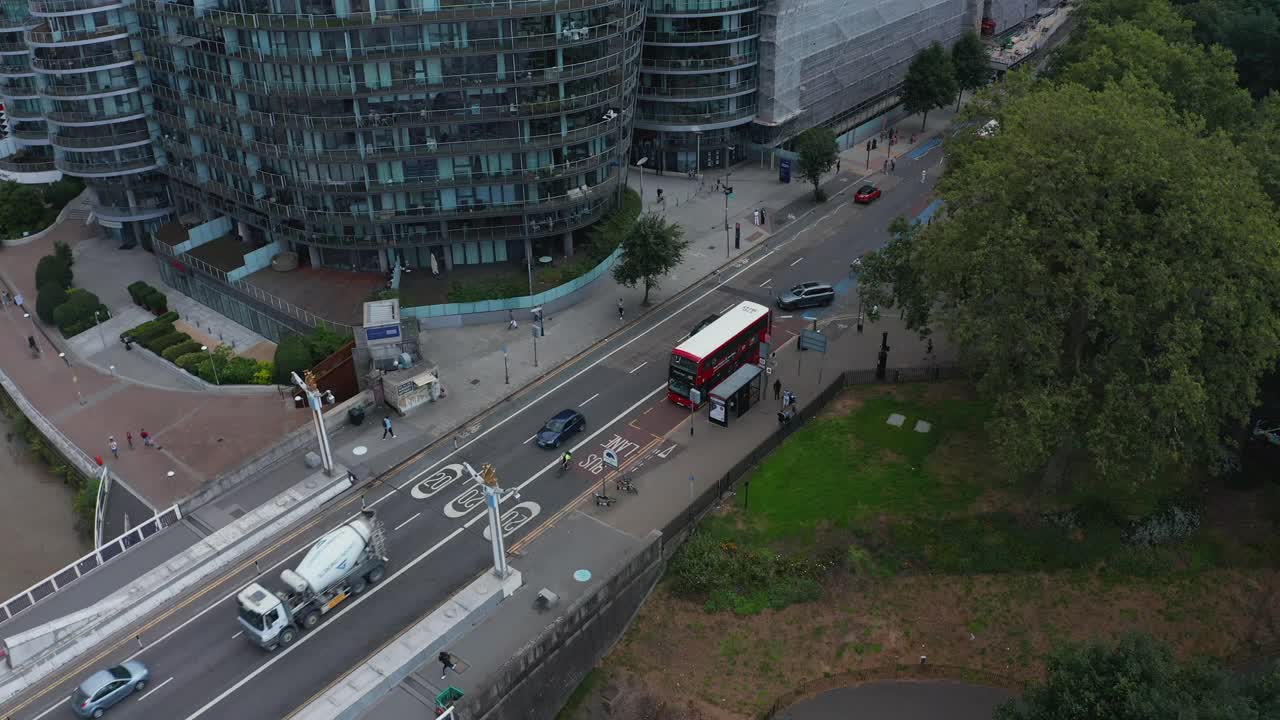 现代住宅小区道路鸟瞰图。圆形的公寓。红色双层巴士站在公共汽车站。英国伦敦视频素材