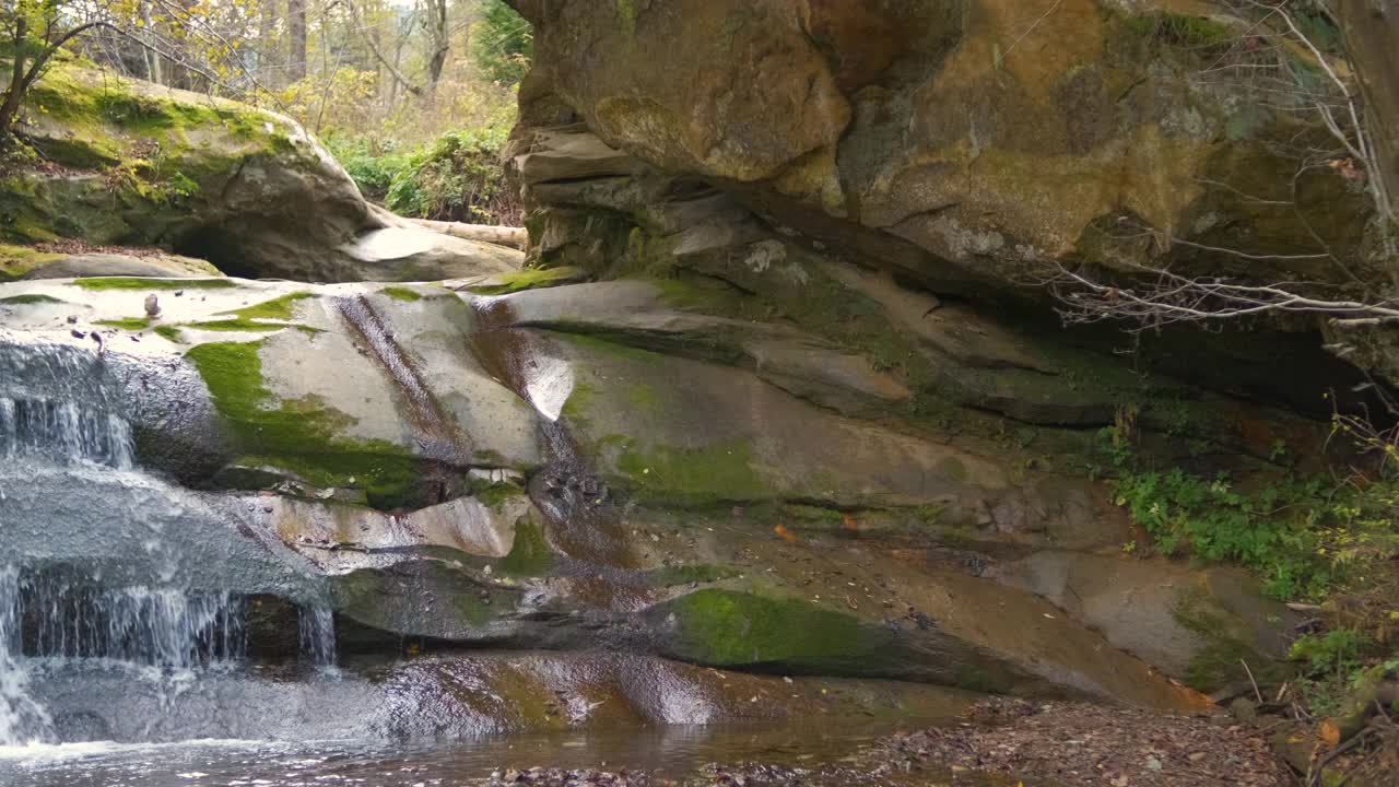 秋天在岩石间有快速流动的清澈水流的小山涧。视频素材