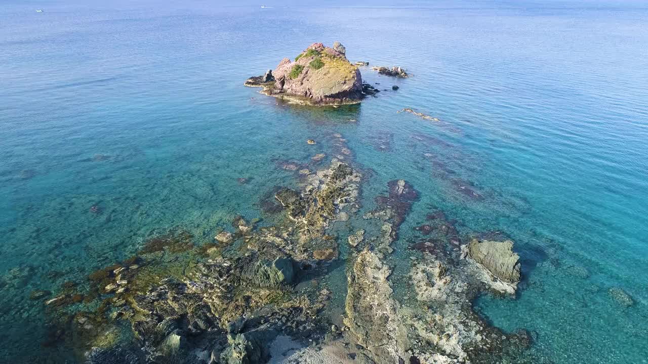 一个孤独的岩石峰在开放的海，鸟瞰。海浪在美丽的海滩上，无人机4k拍摄视频素材