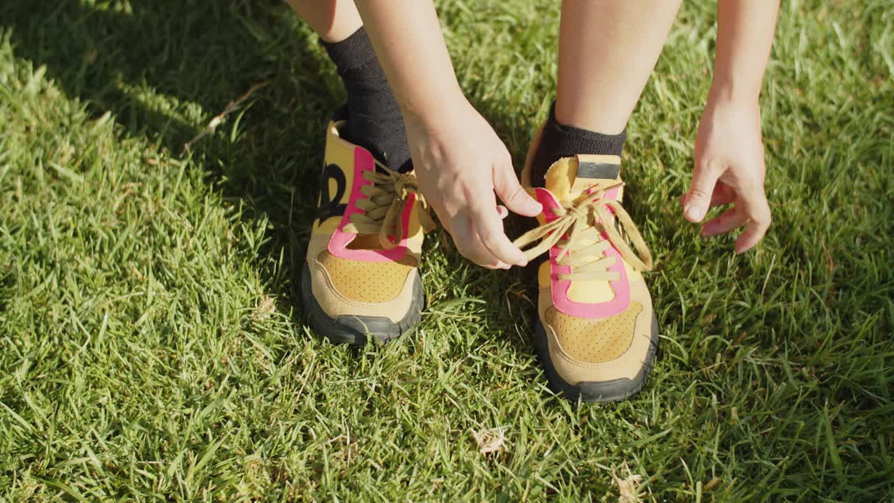 女子在夏季公园系鞋带运动鞋中景视频素材