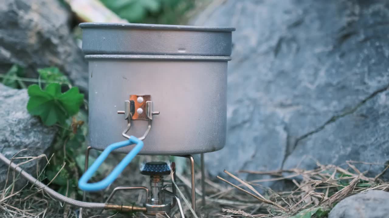 在煤气灶上将水和蒸汽煮沸。在徒步旅行中准备升华物。视频素材