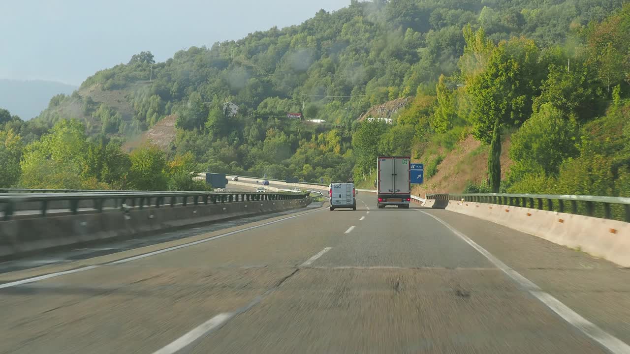 汽车视角驾驶。汽车在阳光和雨水中行驶在弯曲的公路上。视频素材