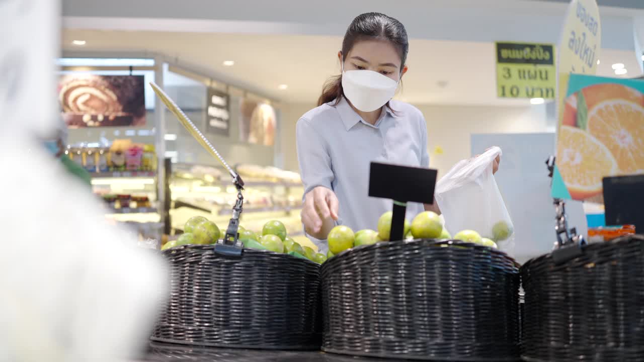 亚洲女孩戴口罩保护她的脸在超市购物视频素材