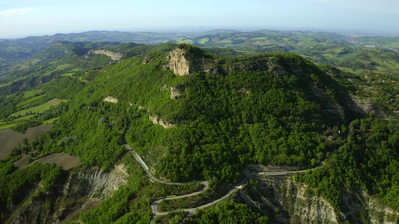 汽车在道路上移动的空中风景，无人机向后飞过山上的绿树-亚平宁山脉，意大利视频素材