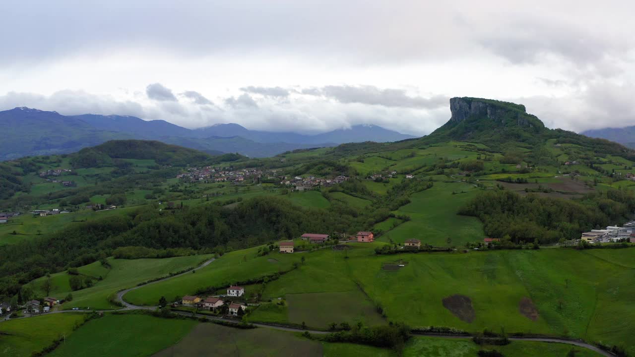 在绿色山丘上建造的住宅的鸟瞰图对多云的天空-亚平宁山脉，意大利视频素材