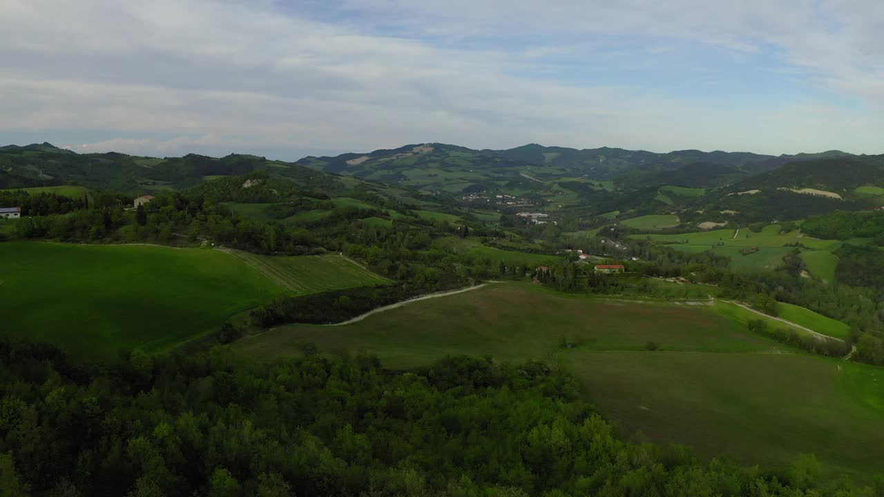 绿色山丘上的空中住宅，无人机飞过植物和树木景观-意大利亚平宁山脉视频素材