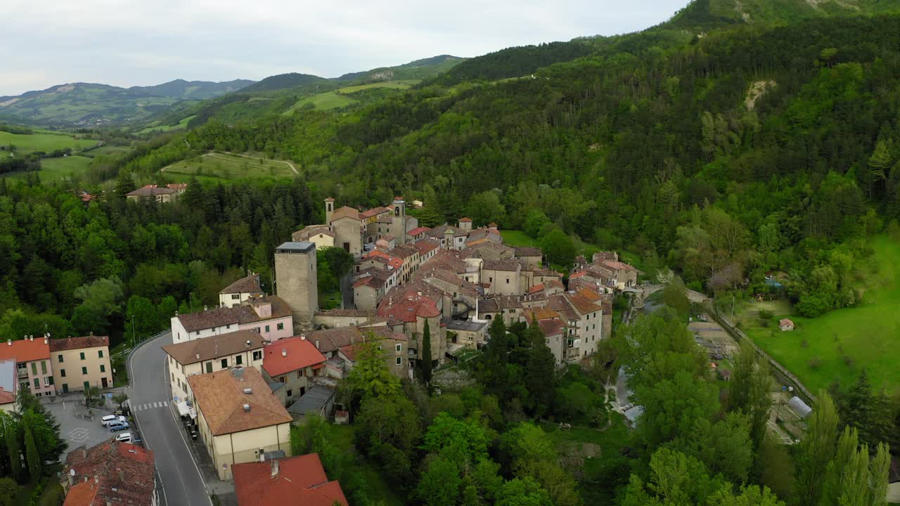 在山上的住宅建筑的空中风景，无人机飞过绿树-亚平宁山脉，意大利视频素材