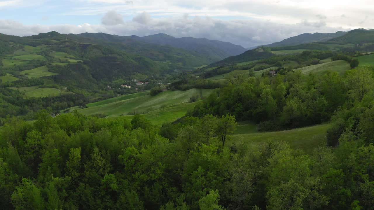 空中美丽的绿色小山在多云的天空，无人机飞行向前的景观-亚平宁山脉，意大利视频素材