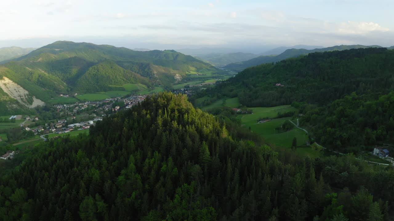 空中平移山坡上房屋景观的美丽镜头，无人机飞过绿树和道路-亚平宁山脉，意大利视频素材