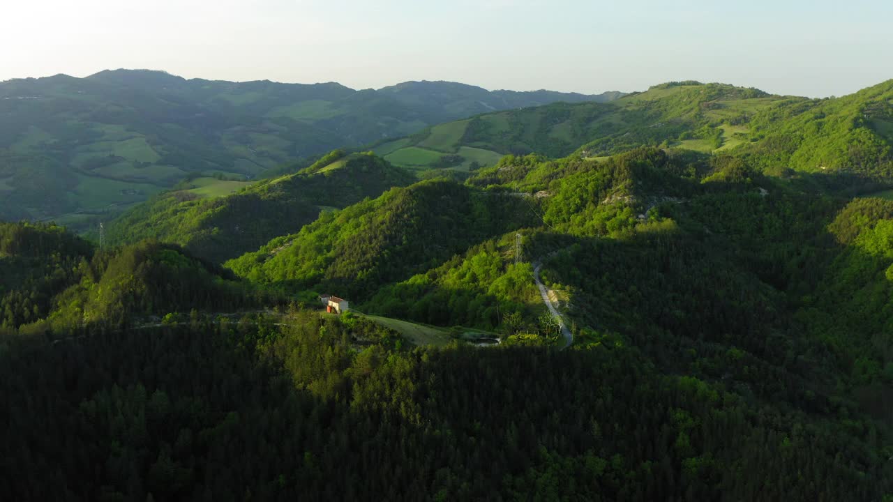 在山上的建筑的空中风景，无人机在绿色景观上飞行前进-亚平宁山脉，意大利视频素材