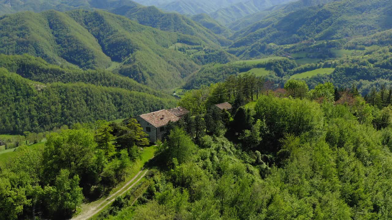 绿色山顶上的房屋的鸟瞰图，无人机飞过树木-亚平宁山脉，意大利视频素材