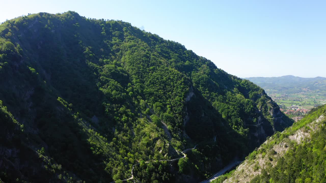 在丘陵景观上的房子的空中美丽的镜头，在阳光明媚的日子里无人机飞过绿色的山脉-亚平宁山脉，意大利视频素材