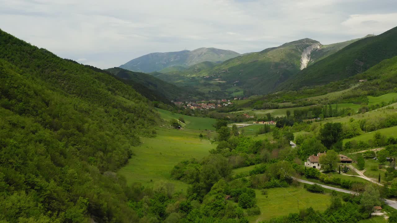 空中:山丘上的住宅建筑的美丽镜头，无人机在绿色景观上飞行前进-亚平宁山脉，意大利视频素材