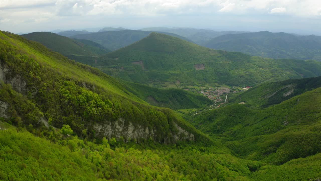 在小山景观上建造的房屋的空中风景，无人机在绿树上飞行前进-亚平宁山脉，意大利视频素材