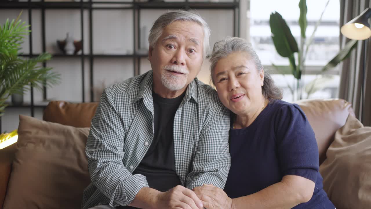 一对亚洲老夫妇通过摄像头聊天，与远方的家人进行视频通话视频素材