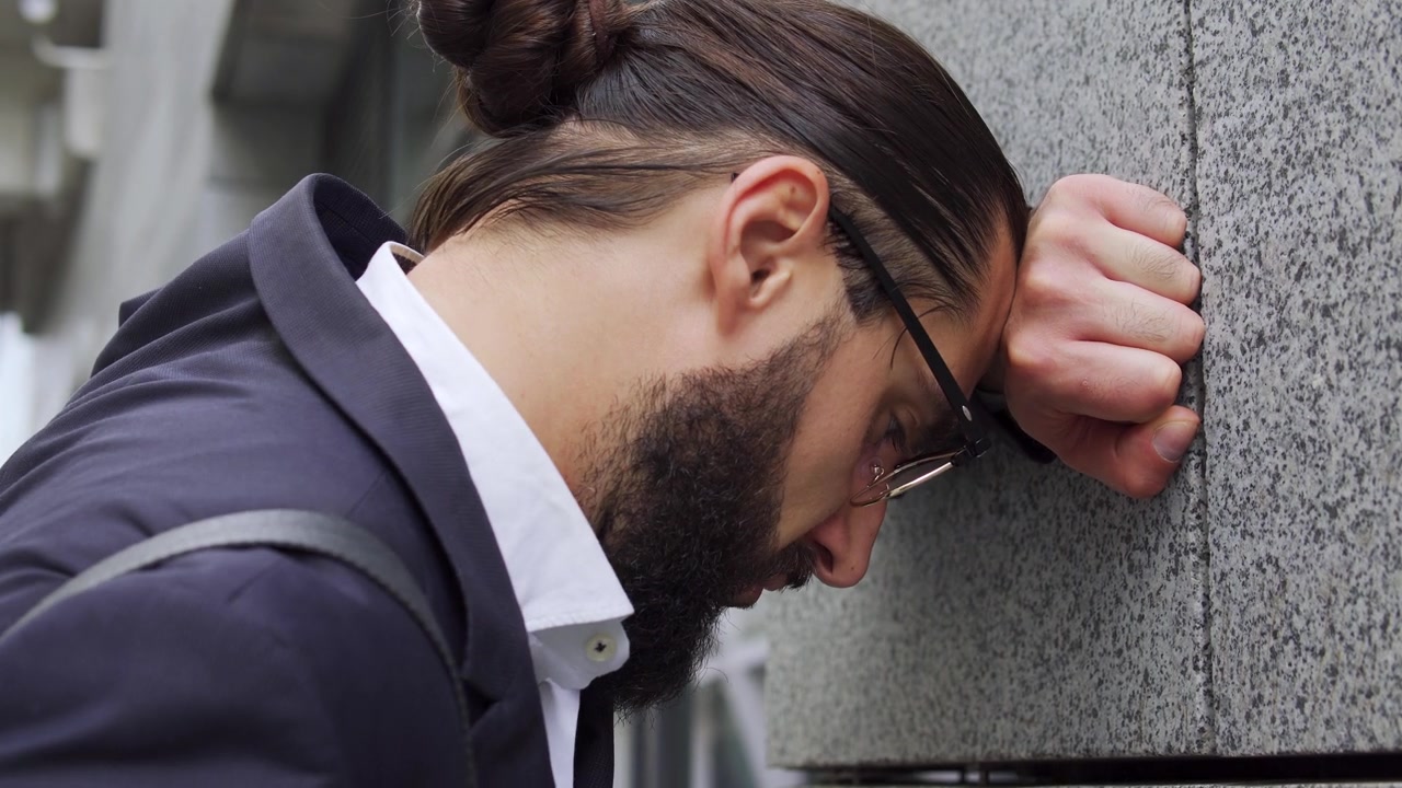 发型时髦的悲伤男人把头砸在墙上，律师失败了重要的案件视频素材画面3