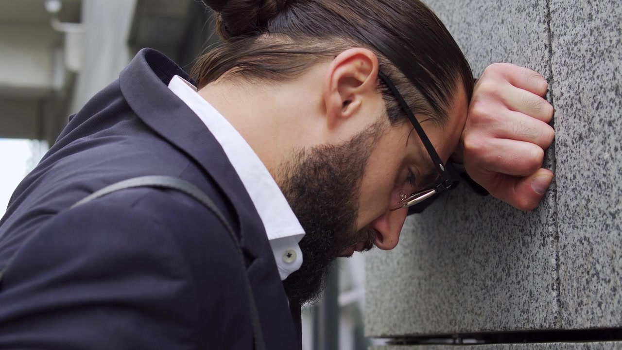 发型时髦的悲伤男人把头砸在墙上，律师失败了重要的案件视频素材画面4