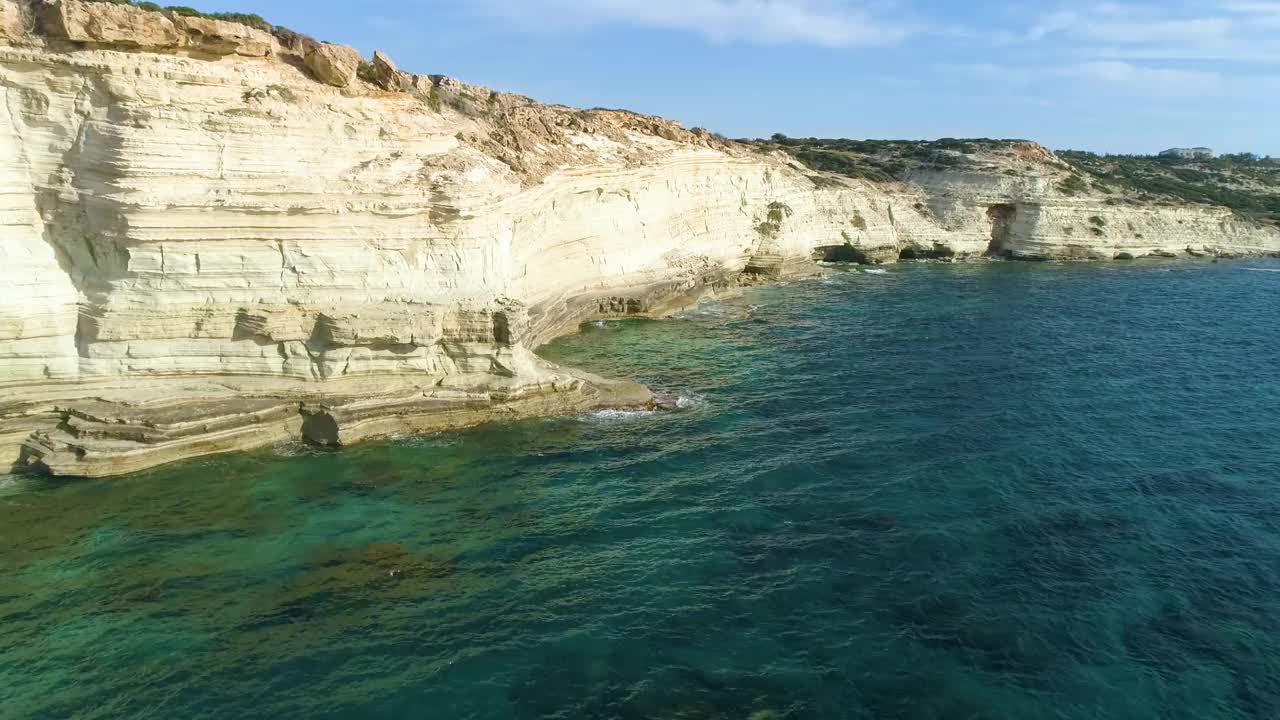 鸟瞰海滨，海与山，陡峭的岩石悬崖，美丽的旅游景观。蓝绿色海洋无人机4k拍摄的白色悬崖。水波撞击岩石视频素材