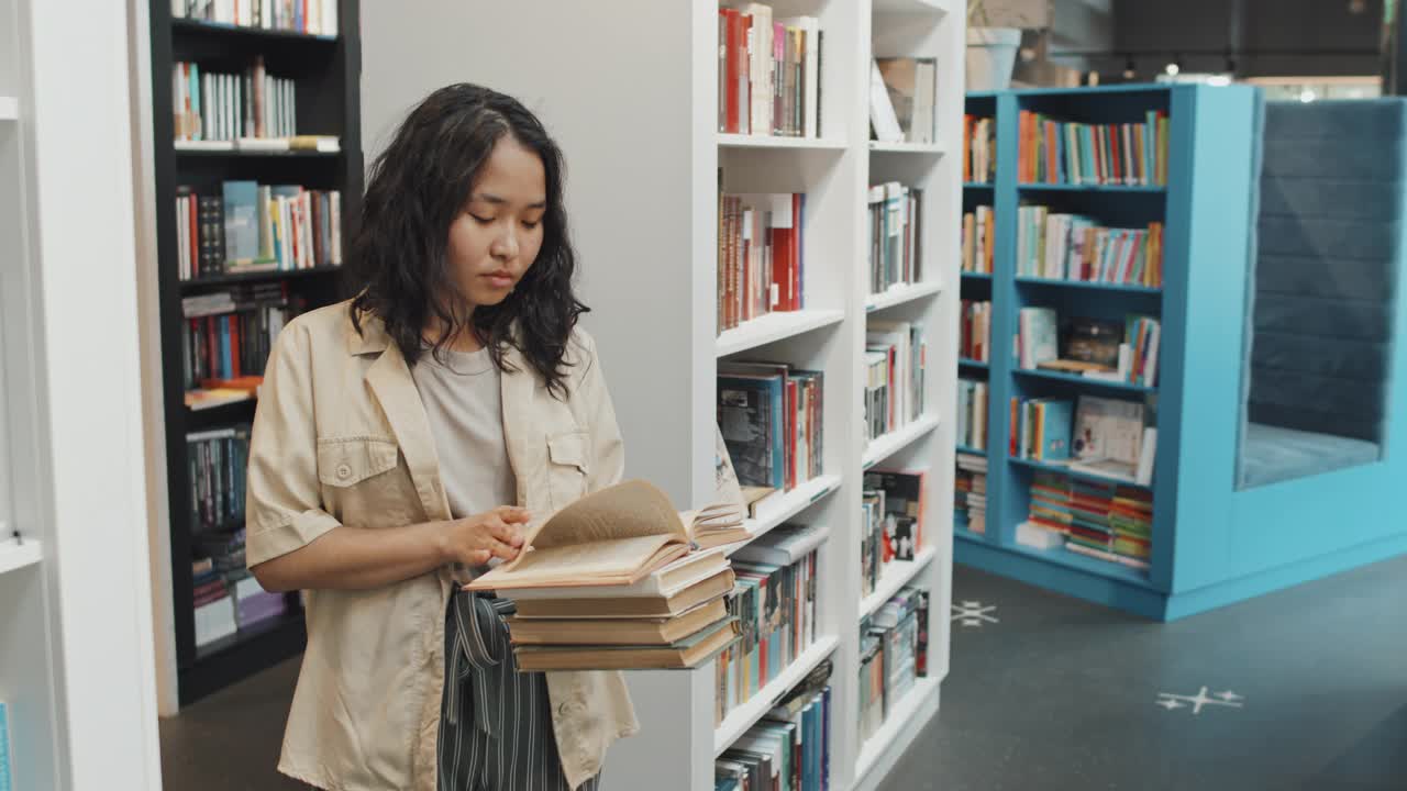 亚洲女学生在图书馆看书视频素材