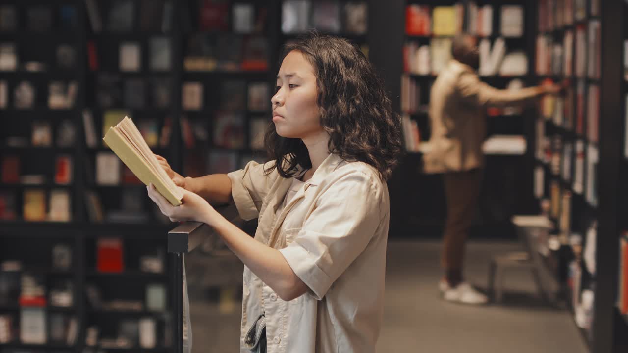 亚洲女学生在现代图书馆读书视频素材