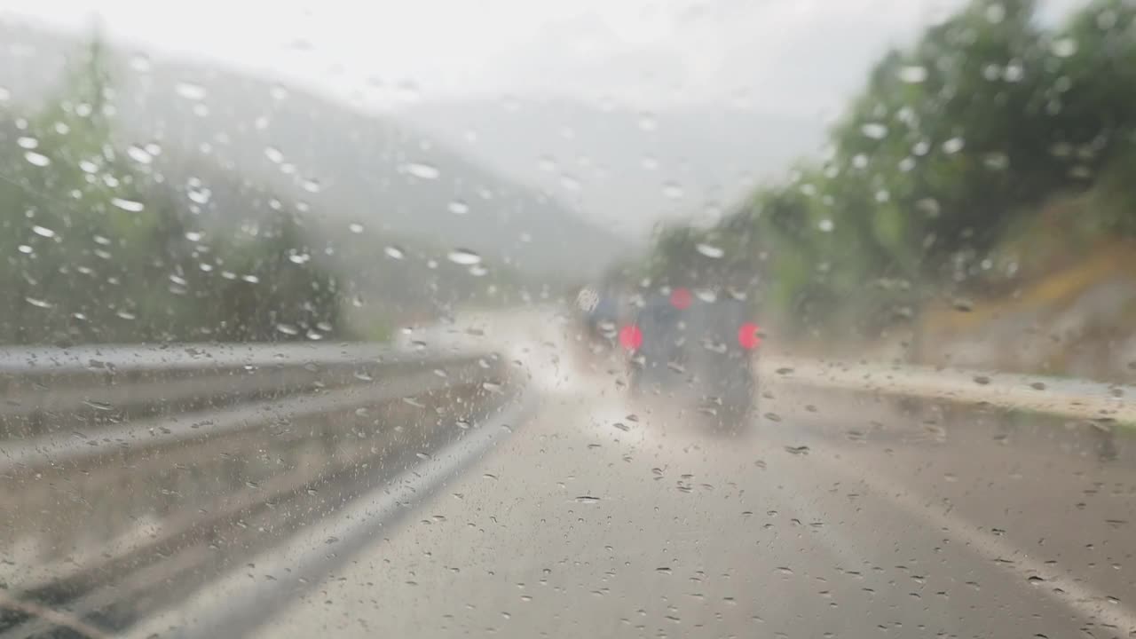 汽车视角行驶在下雨的公路和挡风玻璃雨刷清理从一个大而强烈的风暴的雨视频素材