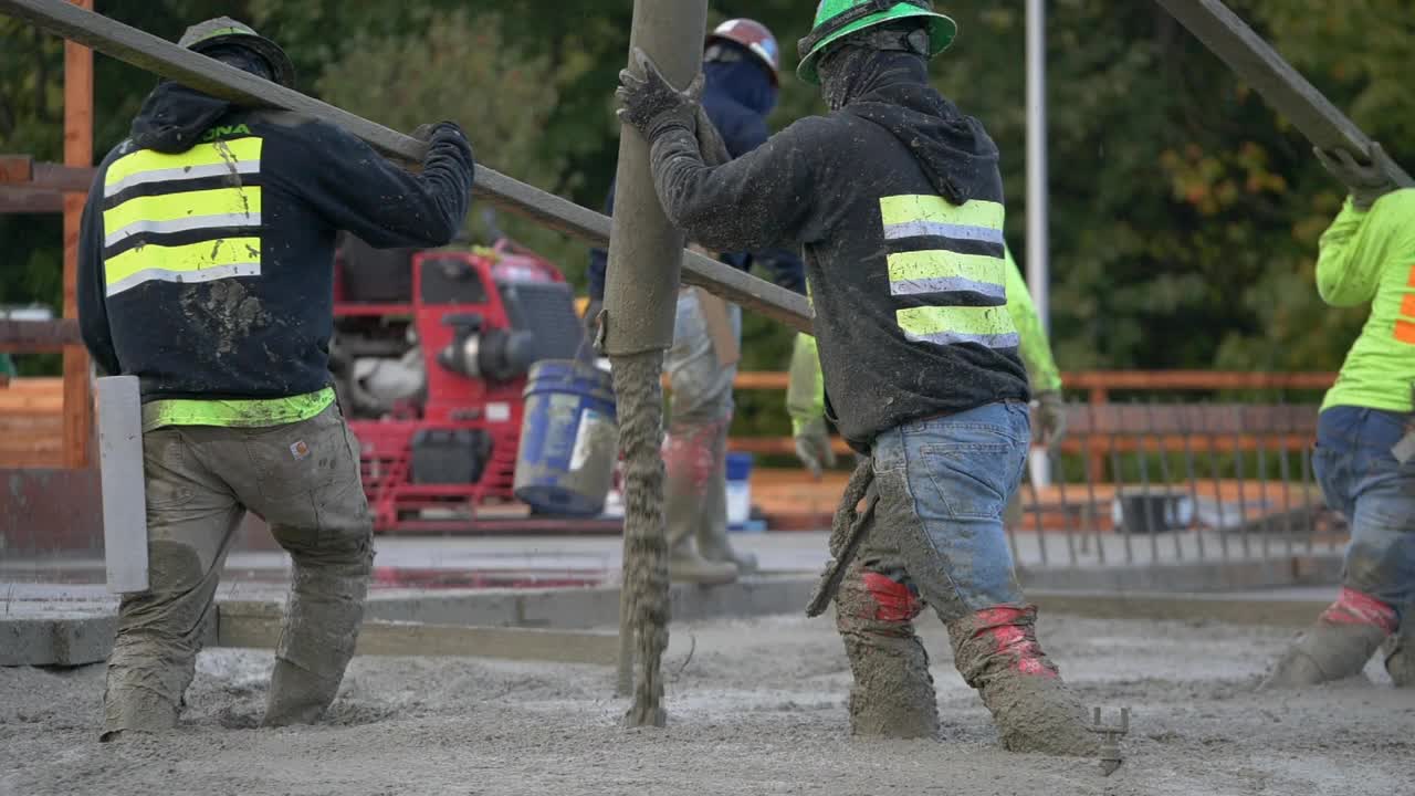 建筑工人在一个大型商业工地浇筑混凝土。视频下载