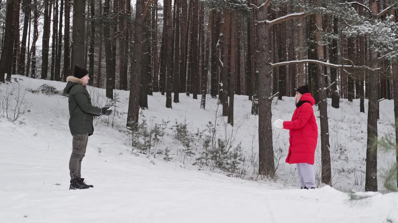 幸福的夫妇在森林里抛雪玩乐。视频素材