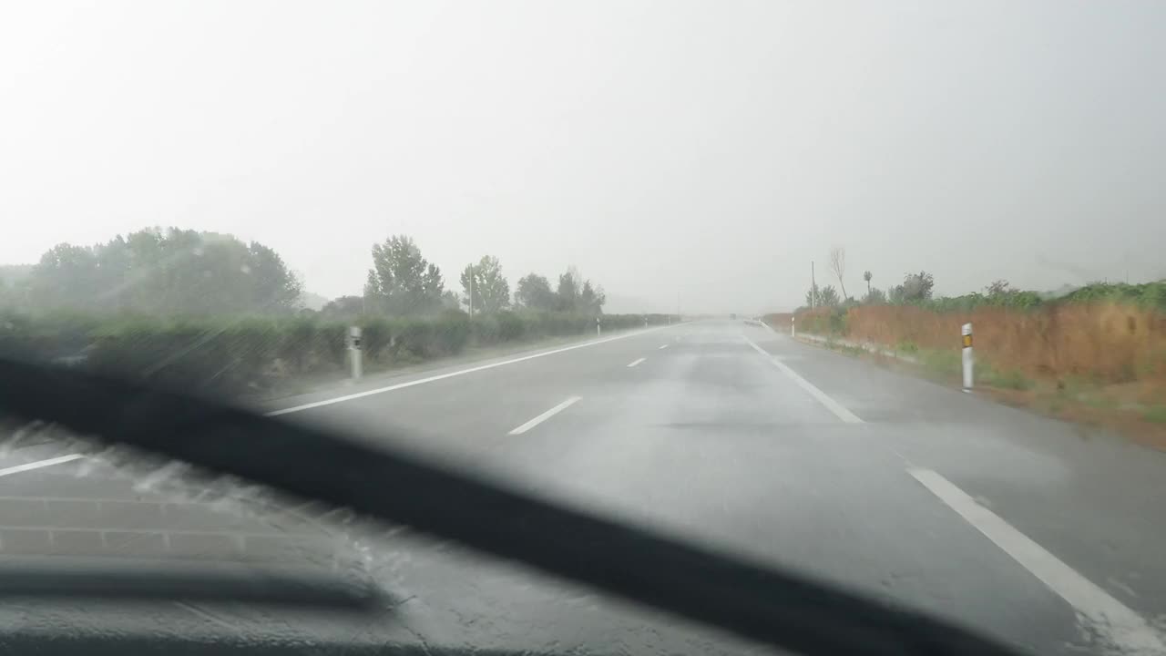 汽车视角行驶在下雨的公路和挡风玻璃雨刷清理从一个大而强烈的风暴的雨视频素材