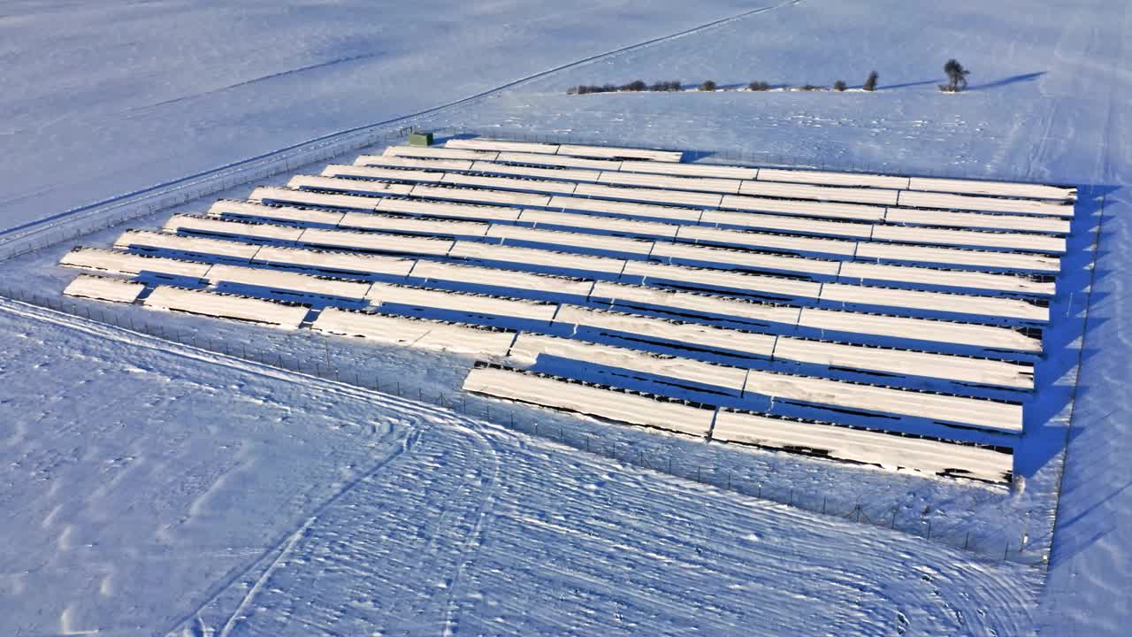 在阳光明媚的冬日，下雪的太阳能电池板。鸟瞰图,波兰视频素材