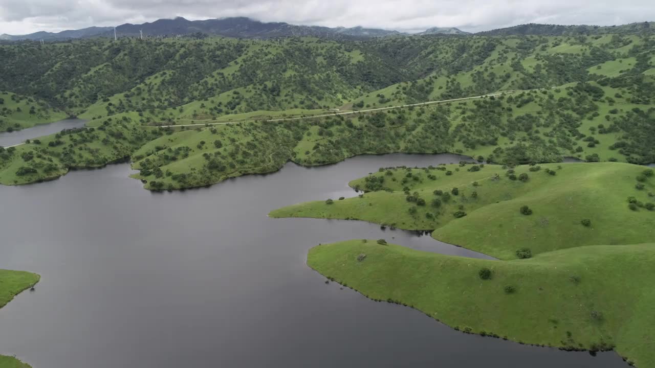 背景中的圣路易斯水库和洛斯巴诺斯附近的上棉白杨河野生动物区。加州。美国。山的背景视频素材