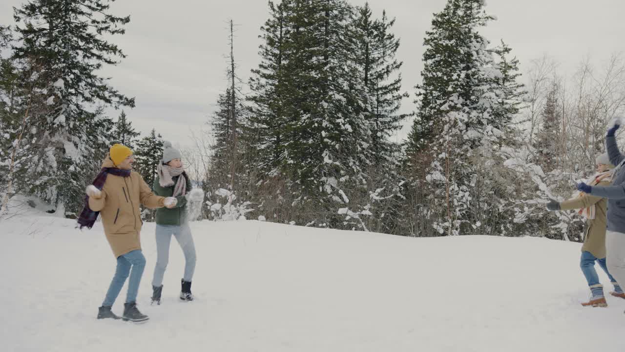 小朋友们在冬天的森林里打雪仗，玩得很开心的慢动作视频素材