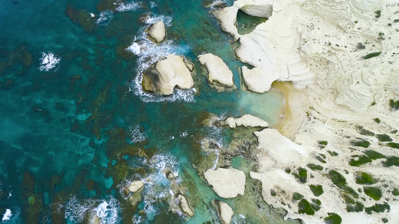 海岸地带，海浪飞溅海滩与岩石背景，在海的悬崖，4k顶塞浦路斯鸟瞰图视频素材