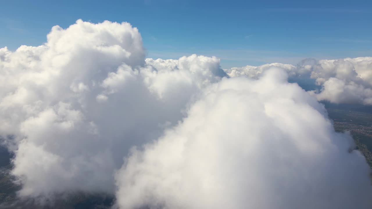 从高空的飞机窗口鸟瞰图，上面覆盖着暴雨前形成的蓬松积云视频素材