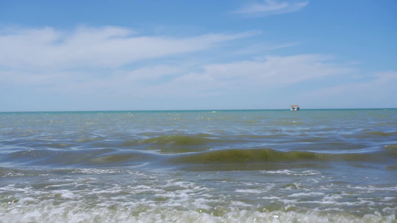 在阳光下，波光粼粼的抵达海岸。视频素材