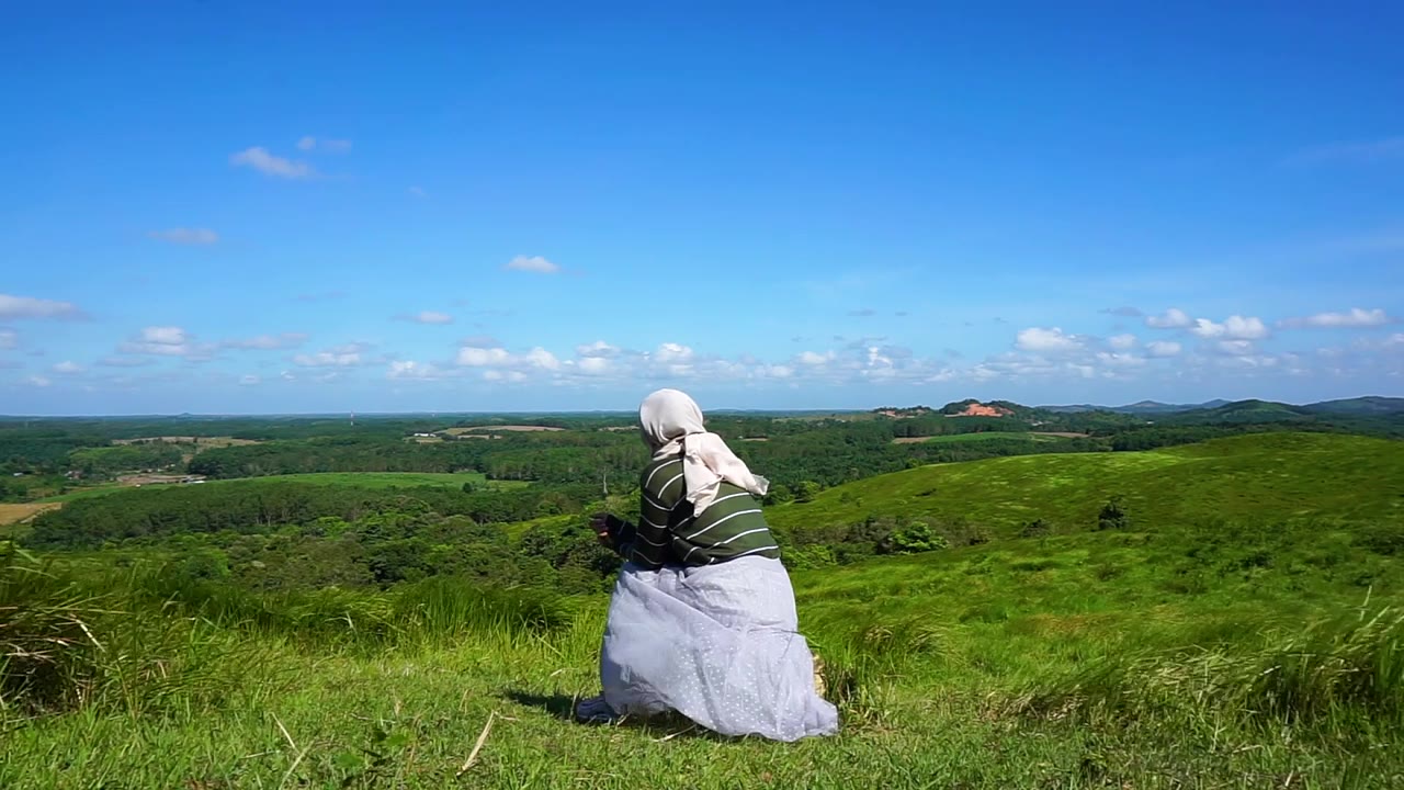 年轻的女人坐在山顶上，自由，放松视频素材画面4