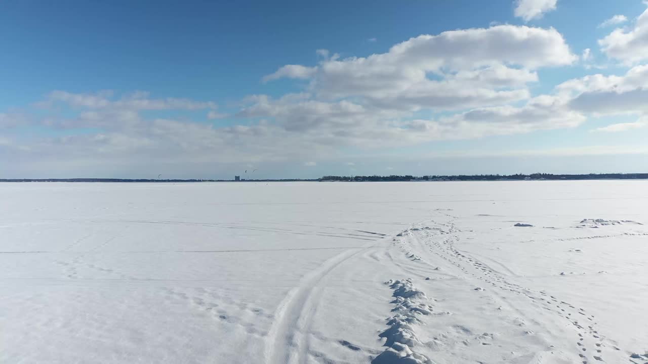 在奥卡，用无人机向后飞，远离风筝，在冬天的皑皑白雪上滑雪视频素材