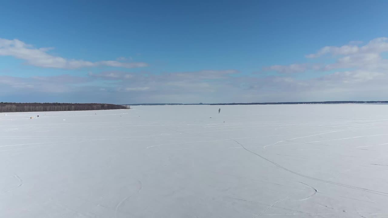 冬季的双山湖高空鸟瞰图，完全被冰雪覆盖，一些风筝冲浪者在Oka享受冬天视频素材