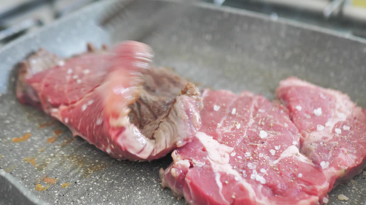 场景特写和旋转的新鲜生牛肉，准备烤肉排视频素材