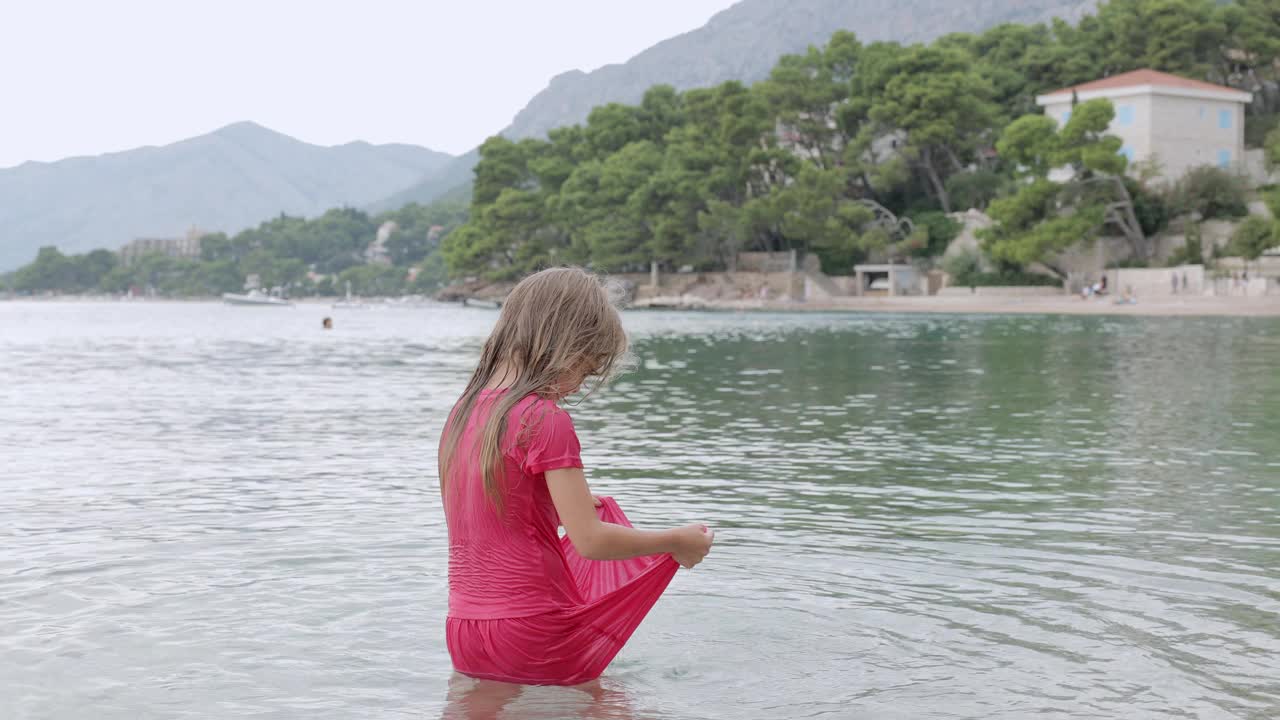 一个小女孩正在海里玩耍。视频素材