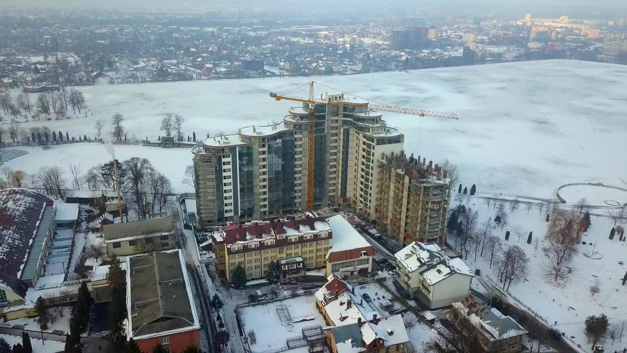 现代高层住宅楼鸟瞰图和施工中的塔吊。视频素材