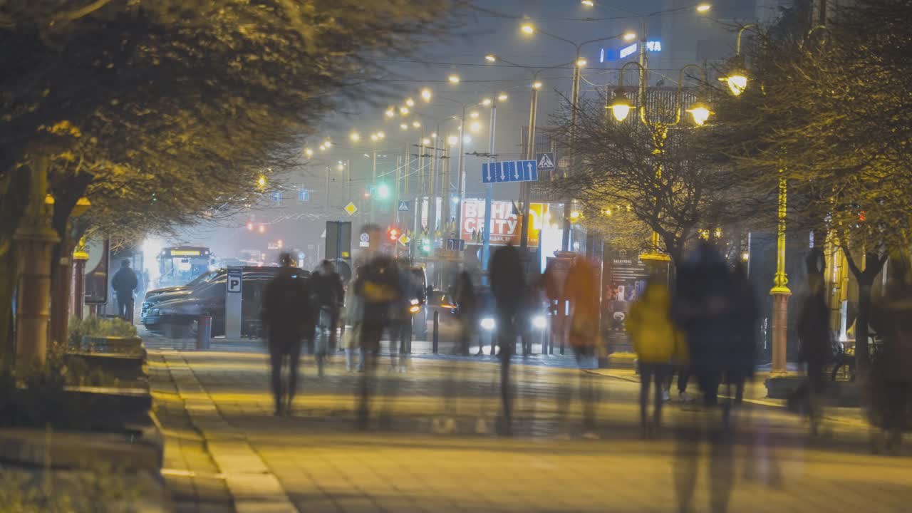 夜晚，在城市步行街上快速行走的上班族模糊轮廓的时间流逝镜头。视频素材